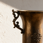 Close-up of the antique gold finish, scrolled cast handle and crest detail