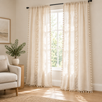 Boho Linen Curtain in natural cream filtering morning light in a bright living room, three-quarter view