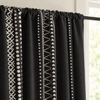 Close-up of the black tribal curtain rod pocket heading gathered on a black rod