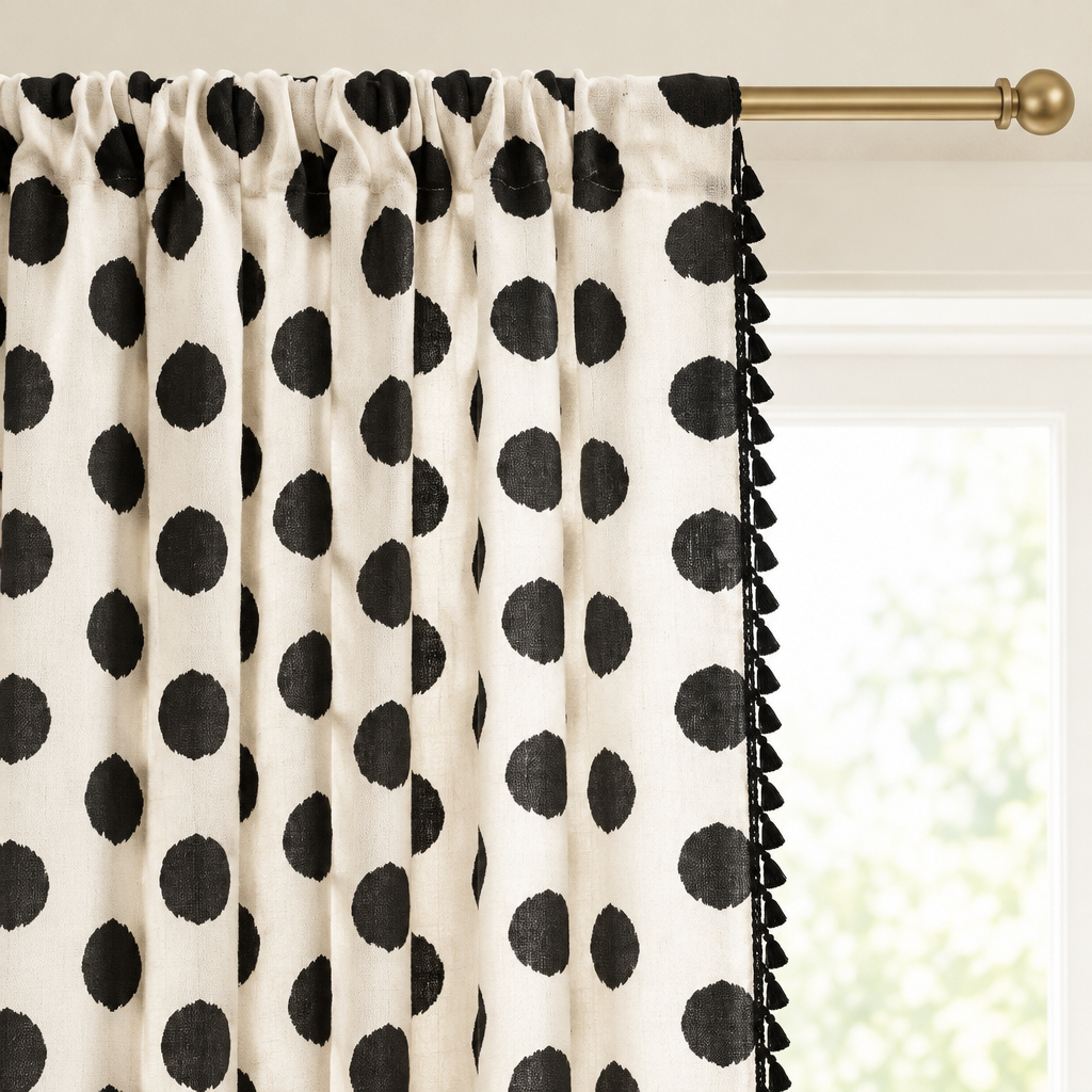 Close-up of the polka dot curtain rod pocket heading gathered on a brass rod