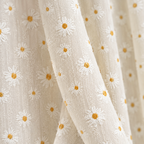 Close-up of the cream textured weave with white and yellow daisies on the Daisy Breeze Cabinet Curtain