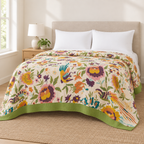 Soft Blossom Breeze Coverlet – blossom print coverlet with green border on a made queen bed in a bright bedroom