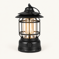 Retro Glow vintage LED lantern in Matte Black, switched on with a warm candle-tone glow