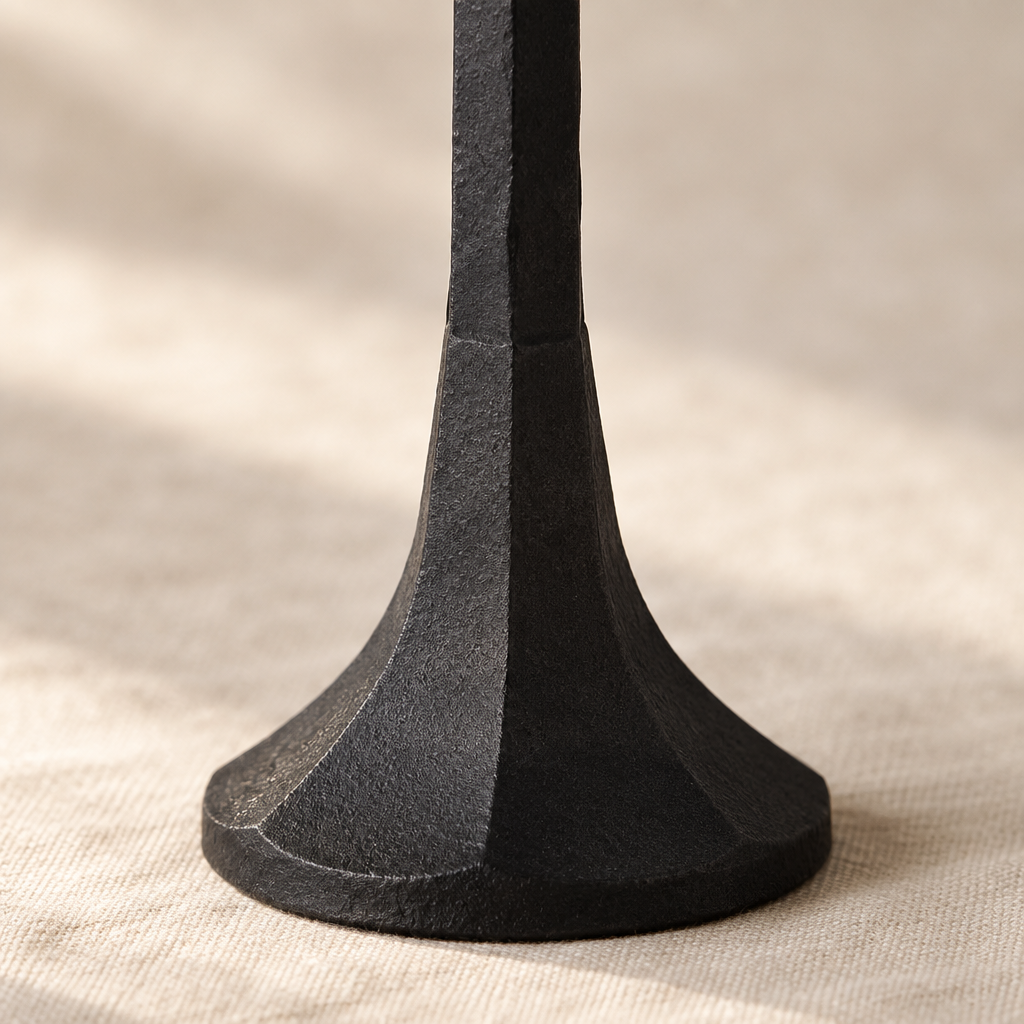 Close-up of the faceted flared base and textured matte black iron finish