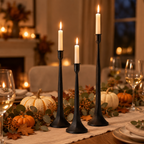 Black iron taper candle holders as a Thanksgiving table centrepiece with pumpkins and eucalyptus