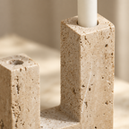 Close-up of natural travertine pores and the taper candle holes on the sculpted holder