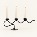 Tri Iron Twisted Candle Holder in Black Swirl with three lit ivory taper candles