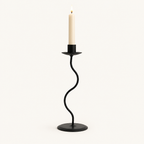 Small 9.4 inch matte black wavy iron taper candle holder with a lit candle