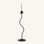 Large 13.6 inch matte black wavy iron taper candle holder with a lit candle