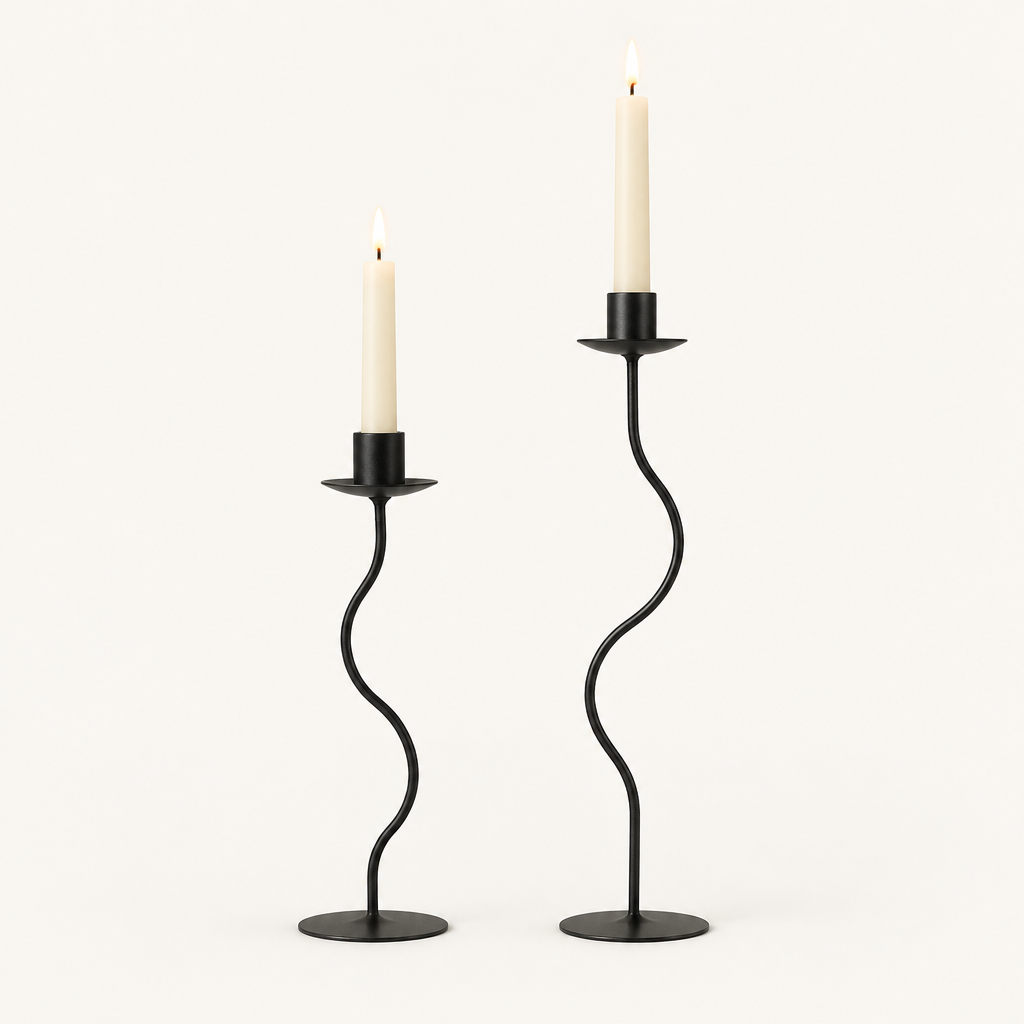 Sculpted wavy iron candle holders in matte black, small and large, with lit taper candles