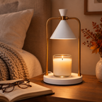 Ivory Gold candle warmer lamp on a bedside table with a knit throw and open book