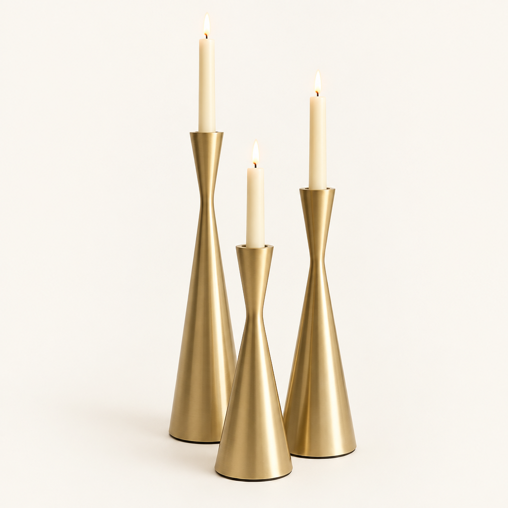 Set of 3 gold hourglass taper candlesticks in Golden Grace with lit ivory candles