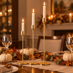 Gold taper candlestick trio as a Thanksgiving table centrepiece with white pumpkins and autumn leaves