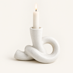 Knot ceramic candle holder, Short, cream speckled, with a lit taper candle