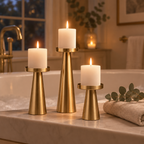 Brass pillar candle holders with lit candles on a bathtub ledge