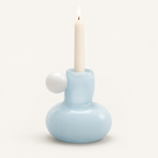 Celestial Nordic glass candle holder in powder blue with white glass ball, holding a lit taper candle