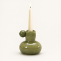 Celestial Nordic glass candle holder in olive green with a lit taper candle