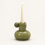Celestial Nordic glass candle holder in olive green with a lit taper candle