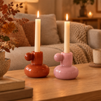 Orange and pink glass candle holders lit on an oak coffee table in a cosy living room