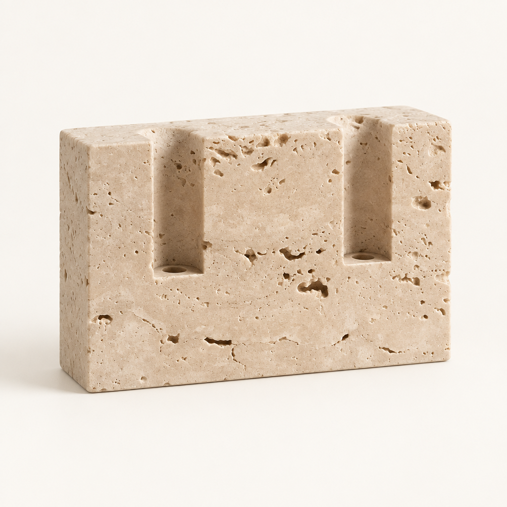Empty travertine taper candle holder showing the natural pitted stone and two slots
