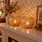 Two Gold Glow Sphere candle holders casting patterned light on a fireplace mantel