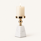 Pyramid marble and gold pillar candle holder, size M, with a lit ivory candle on a warm off-white background