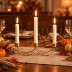 Gold three-candle holder lit as a Thanksgiving table centrepiece with pumpkins and wheat