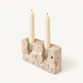 Timeless Glow travertine candle stand, Raw finish, with two lit ivory taper candles