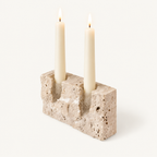 Timeless Glow travertine candle stand, Raw finish, with two lit ivory taper candles