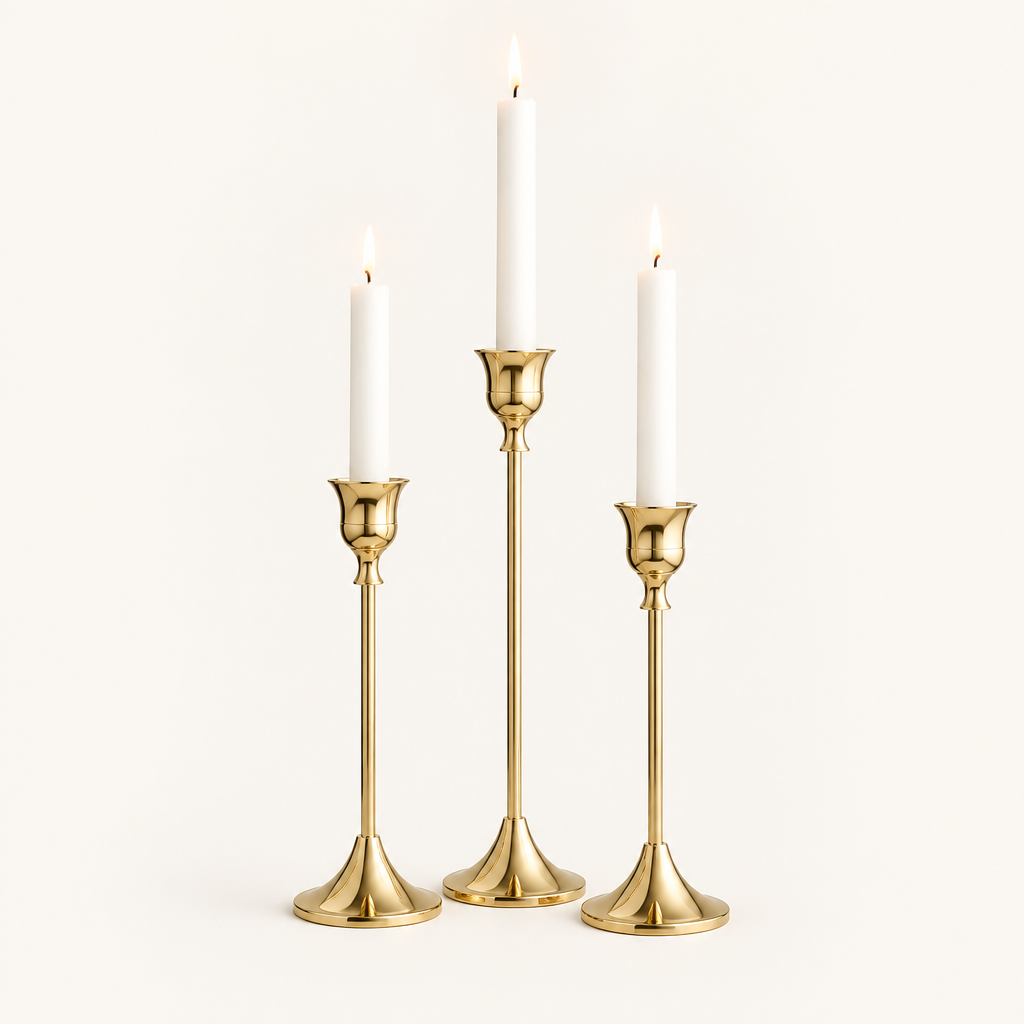 Set of 3 gold taper candlesticks in three heights with lit white candles