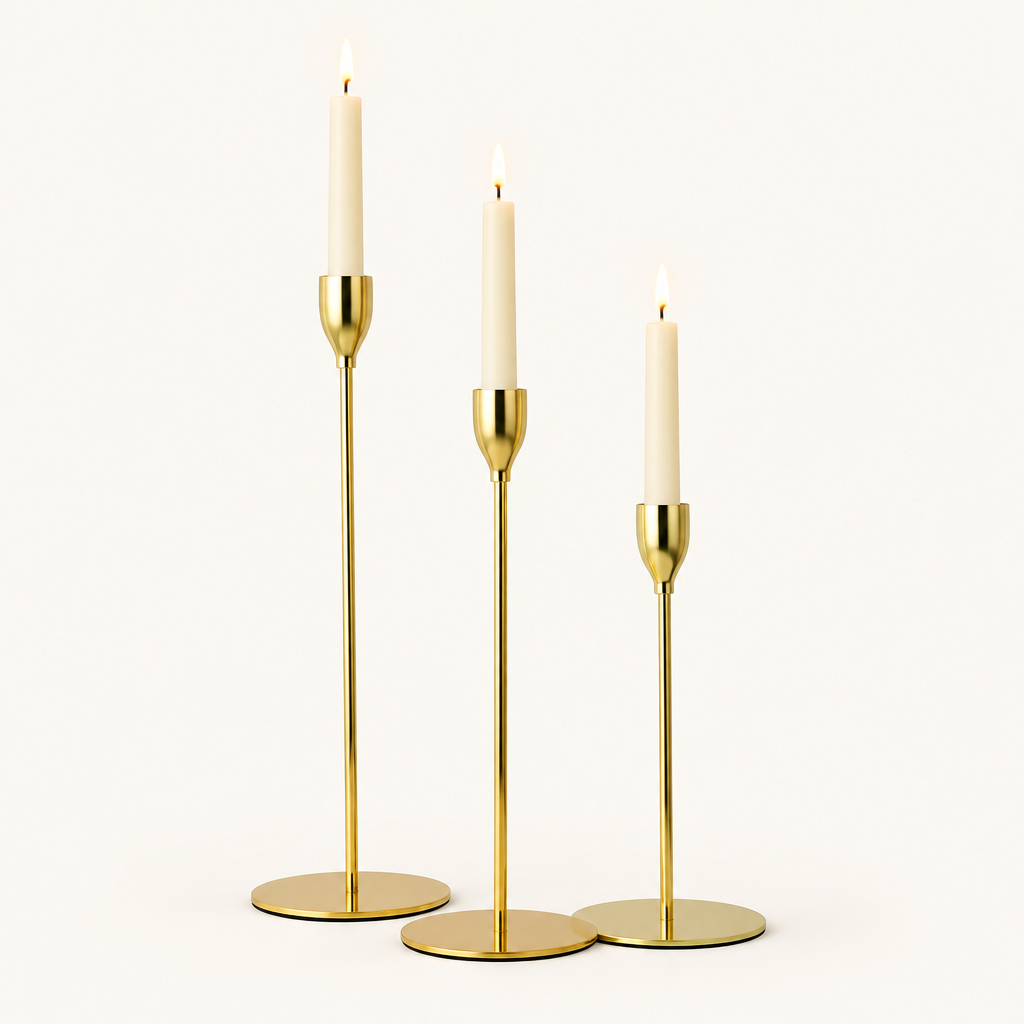 Set of 3 gold metal taper candle holders in three heights with lit ivory taper candles