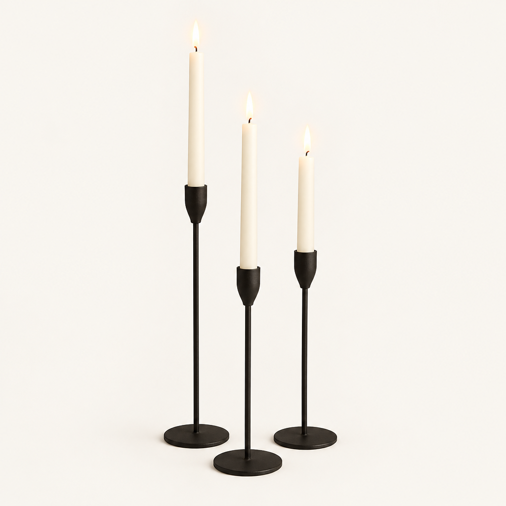 Set of 3 matte black metal taper candle holders with lit ivory taper candles