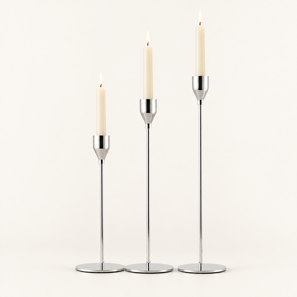 Set of 3 silver metal taper candle holders with lit ivory taper candles