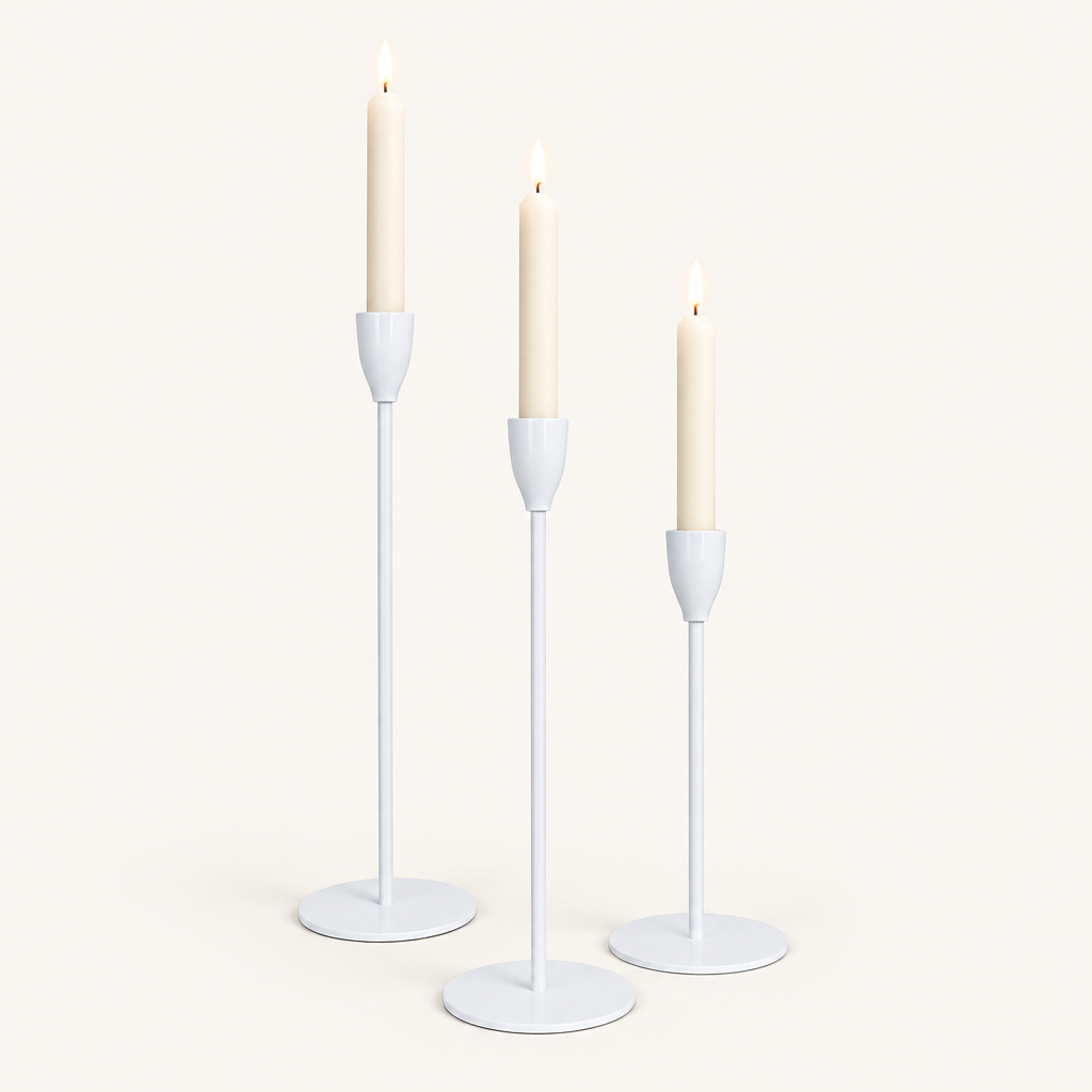 Set of 3 matte white metal taper candle holders with lit ivory taper candles